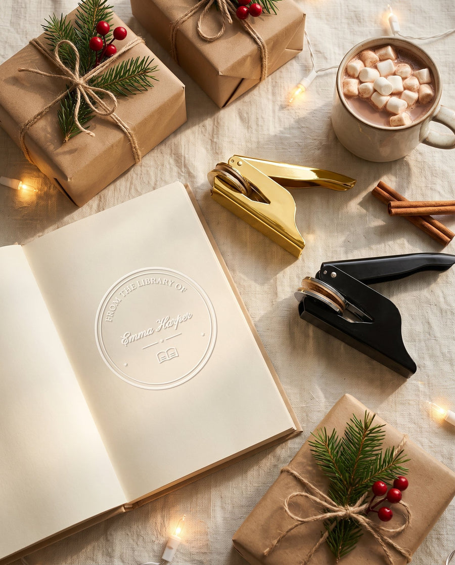 Gold and black book embossers with an embossed book and wrapped Christmas gifts